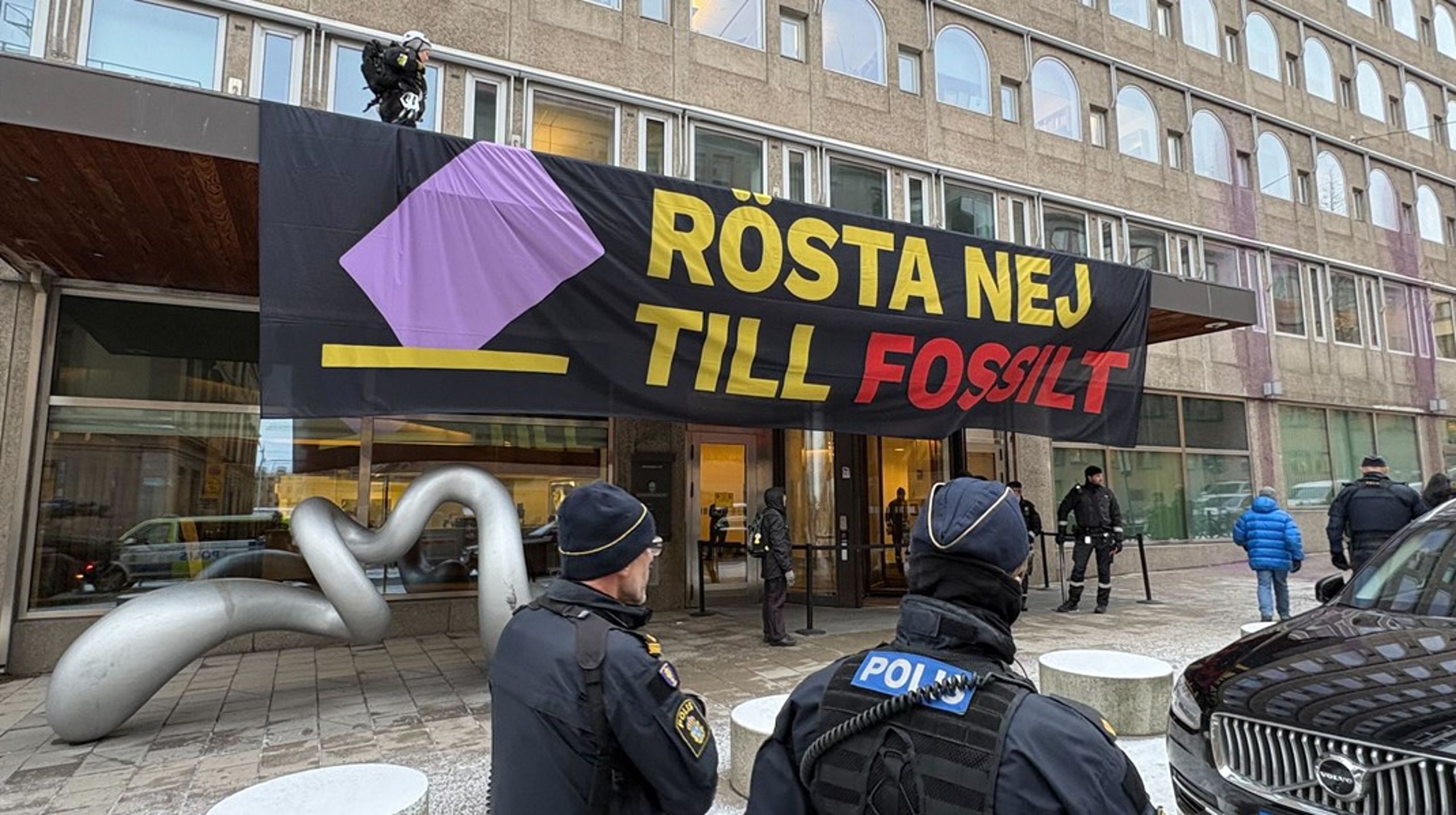 Aktivister ska ha klättrat upp på taket till finansdepartementets entré för att sätta upp banderollen.