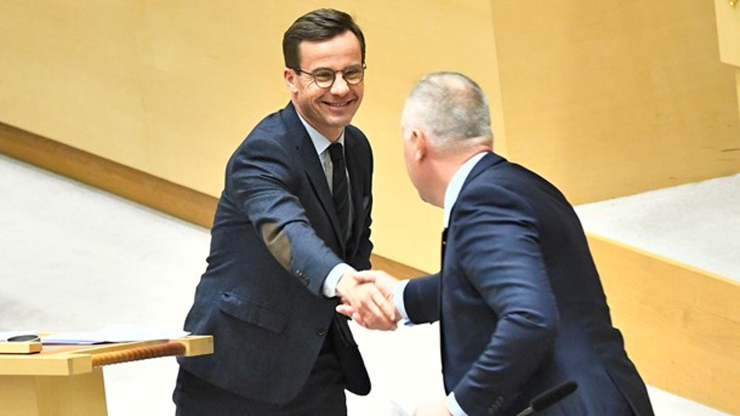 Ulf Kristersson (M) och Jonas Sjöstedt (V) skakar hand under partiledardebatten i riksdagen.