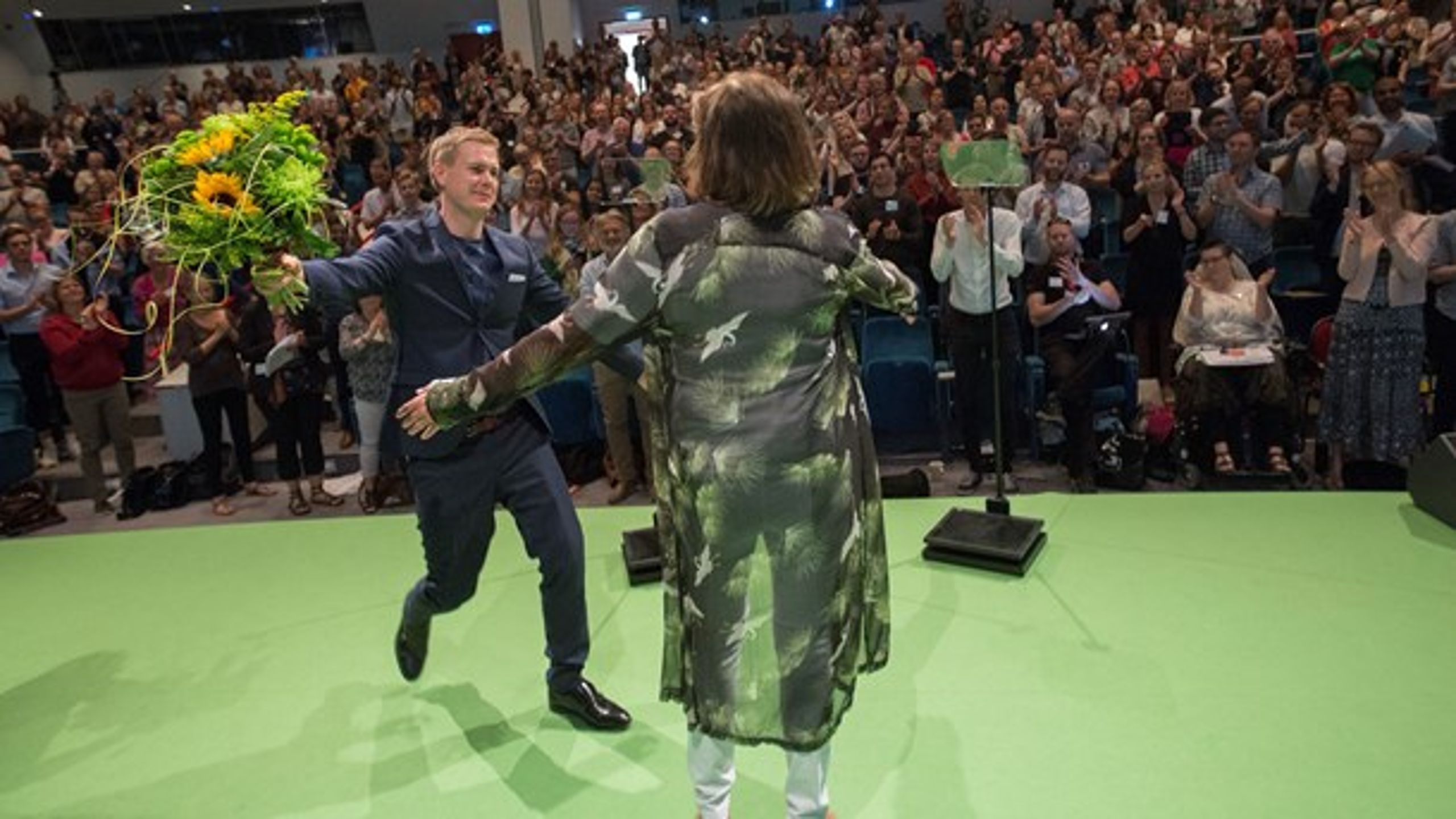 Isabella Lövin (MP) får ett blombukett av Gustav Fridolin (MP) i samband med partiets kongress 2018.