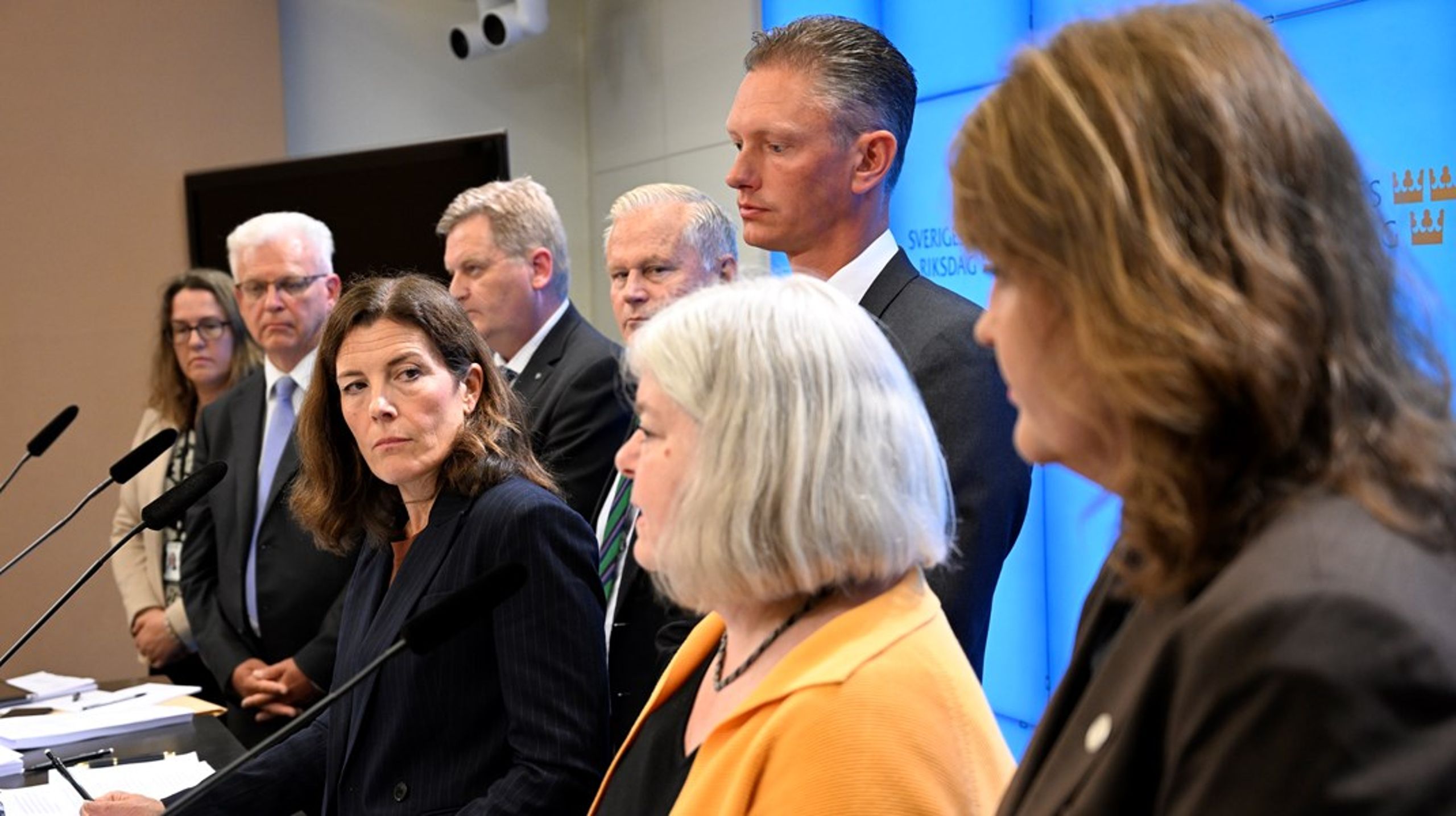 Ett enigt konstitutionsutskott kritiserar delar av regeringens pandemihantering. Från vänster: Camilla Hansén (MP), Tuve Skånberg (KD), Per Schöldberg (C), Hans Ekström (S), Karin Enström (M), Matheus Enholm (SD), Mia Sydow Mölleby (V) och Nina Lundström (L) under utskottets pressträff i riksdagens presscenter.
